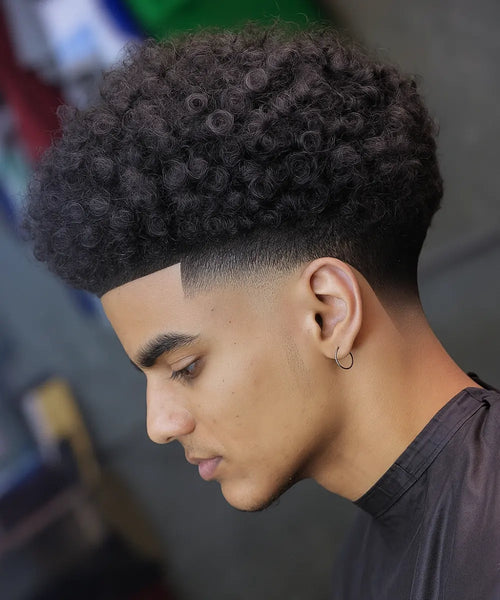 Curly high taper fade with textured volume and clean fade at sides and neckline.