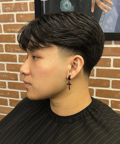 Mid taper fade with straight hair styled in layered flow for a clean, modern men’s look.