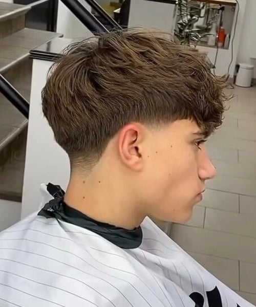 Soft neckline low taper with long, textured top layers styled for flowy volume and natural movement.