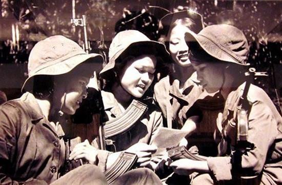 Các cô gái trung đội Vân Dương - Huế chia nhau một bức thư nhà giữa rừng Trường Sơn. (Ảnh: TTXVN)