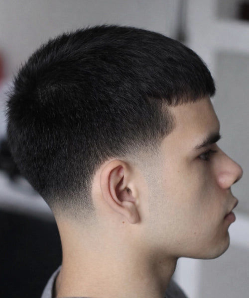 Low taper fade with short textured top and clean taper around ears and neckline for a fresh everyday look